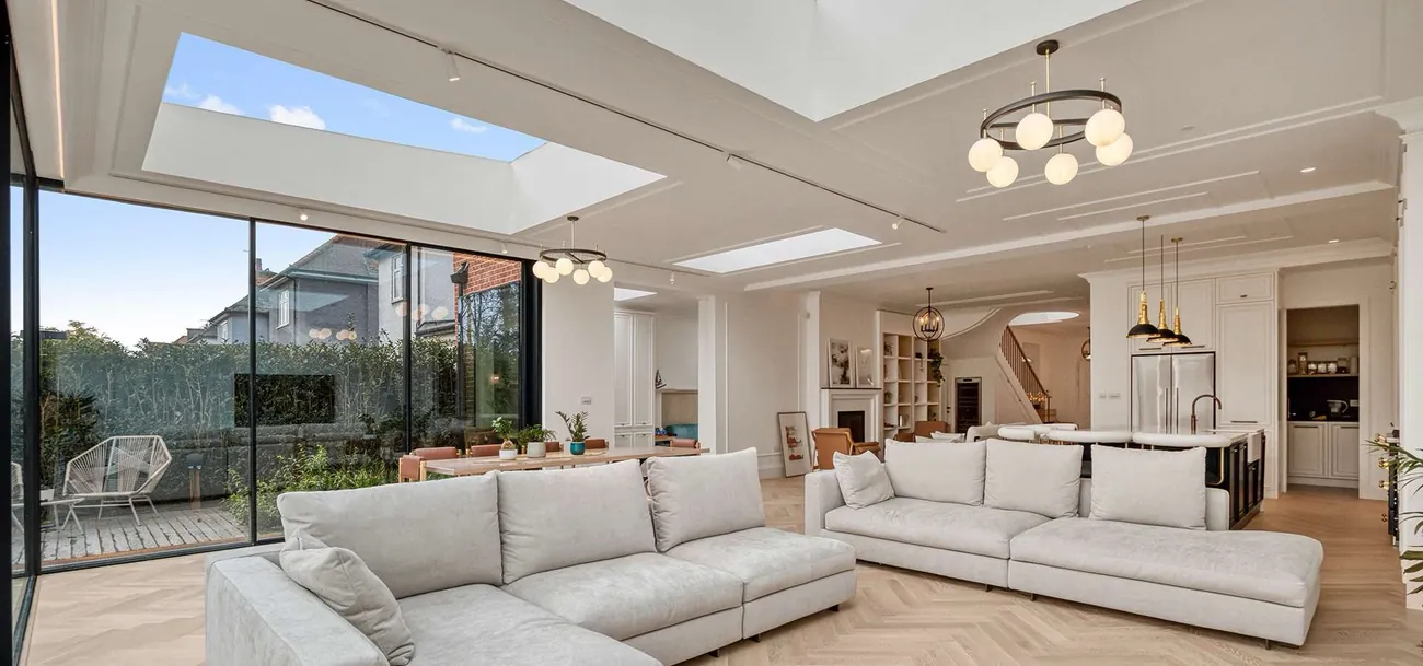 Completed open-plan living, dining and kitchen refurbishment with skylights, herringbone floor and full-height glazing